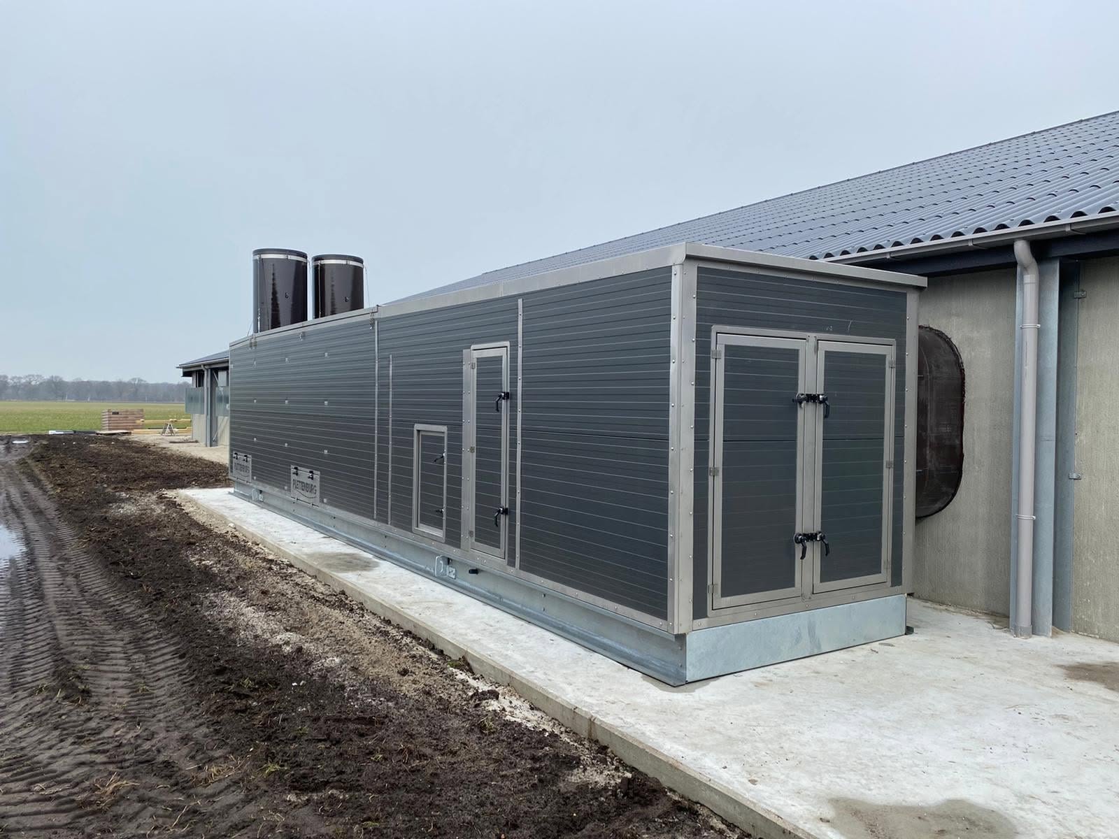 Technische installatie voor stalklimaat naast een agrarisch gebouw